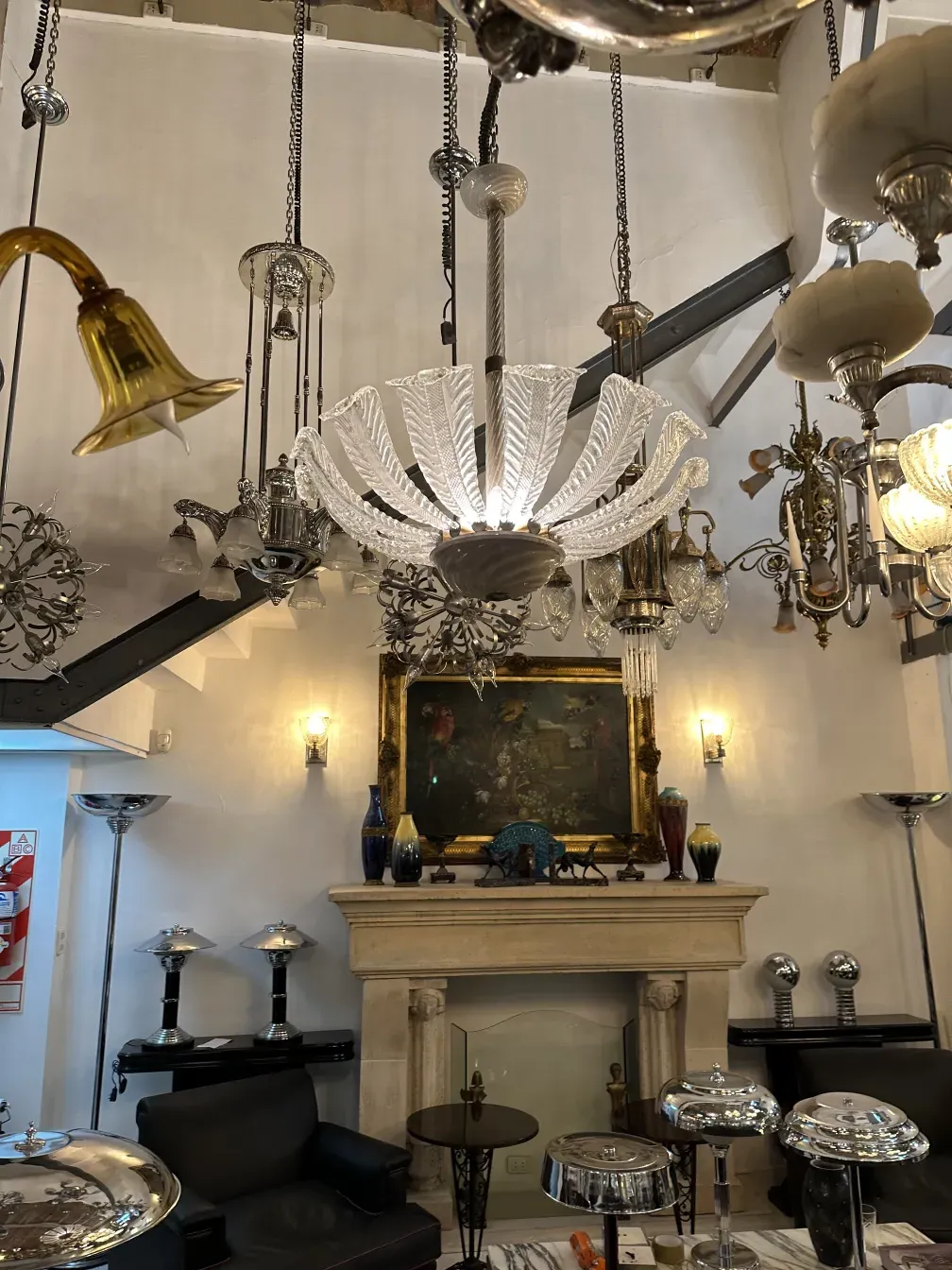 Lampada a sospensione antica con design elegante e forme intricate.