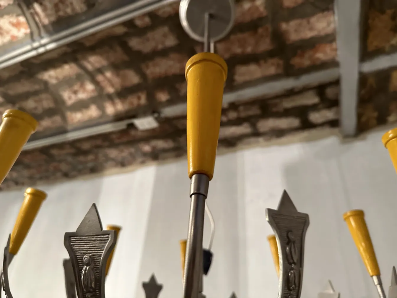 Lampada a sospensione antica con accenti gialli, che illumina uno spazio accogliente.