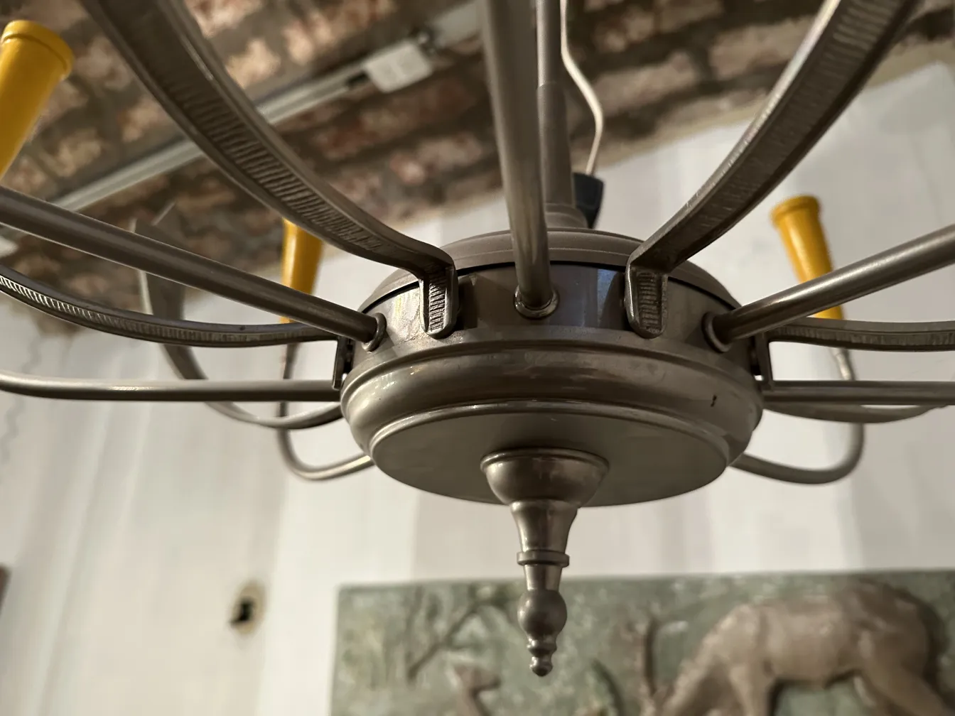 Lampada a sospensione antica con barre dorate e dettagli decorativi, in un ambiente accogliente