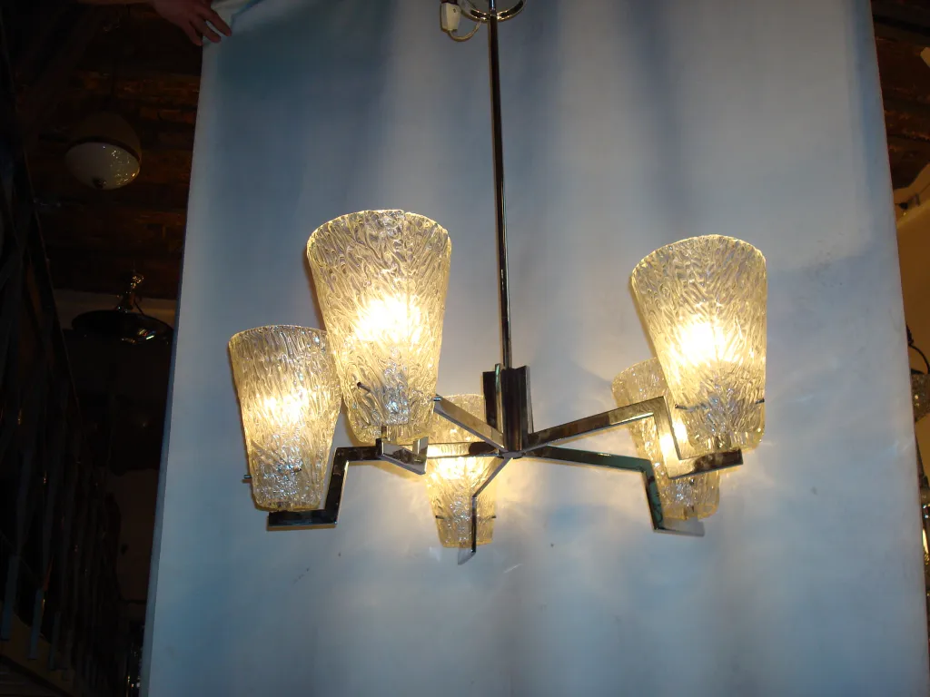 Lámpara de techo antigua con bombillas brillantes y cristales decorativos.