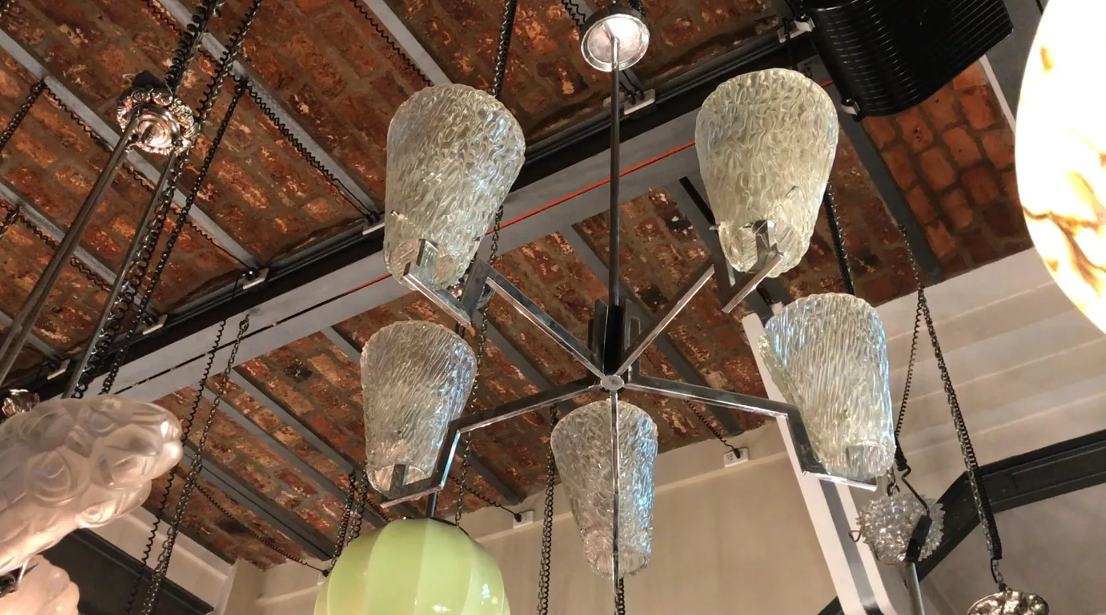 Lampada a sospensione antica con dettagli unici, che illumina un ambiente accogliente.