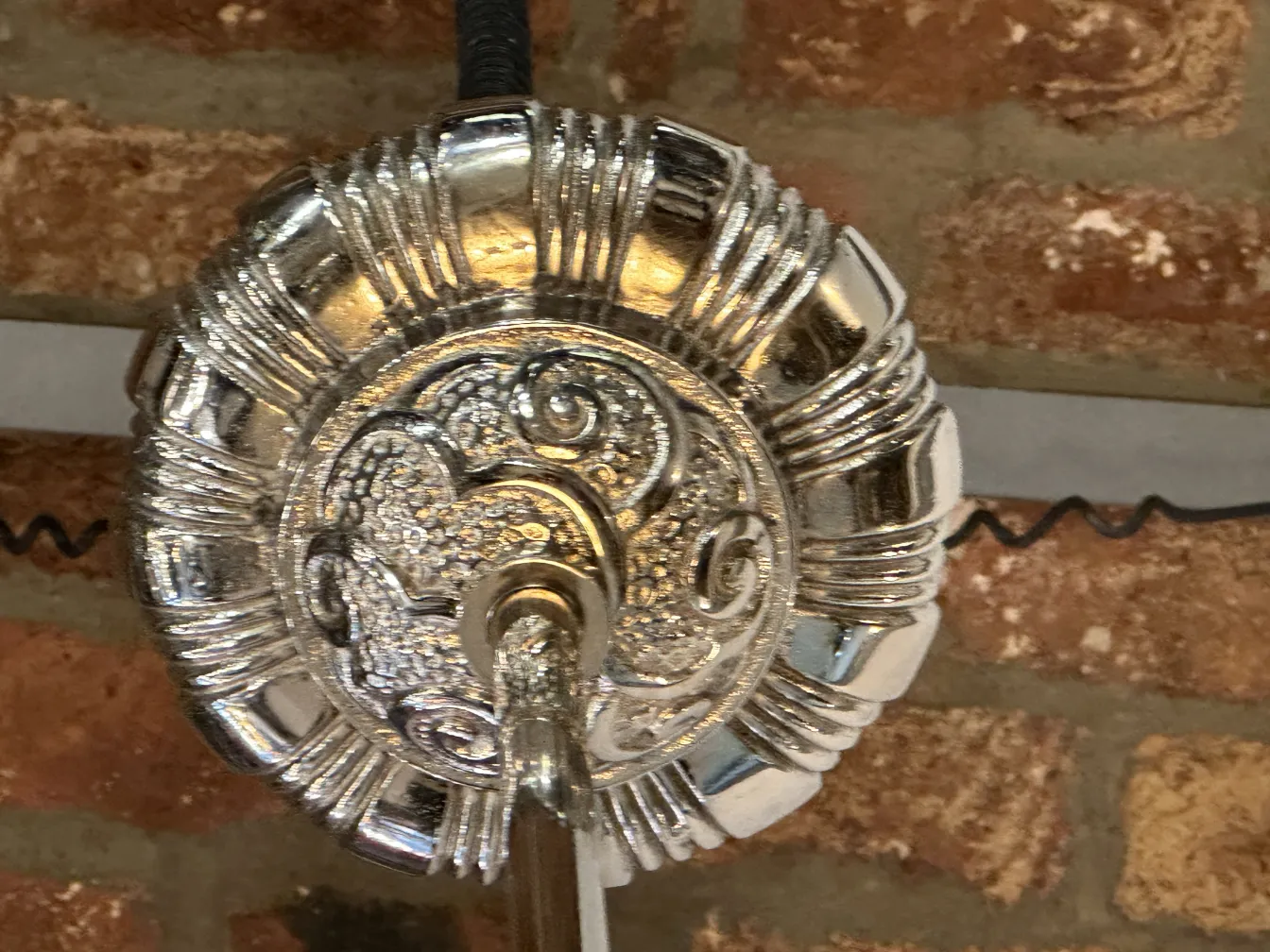 Antique hanging lamp with shiny finish in a cozy setting.