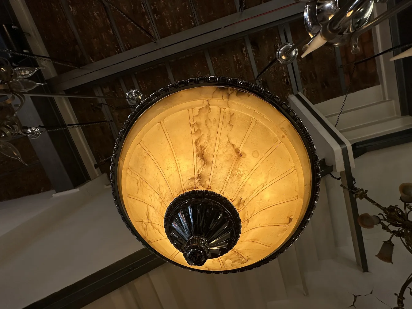 Lámpara de techo antigua con luz suave en ambiente elegante.