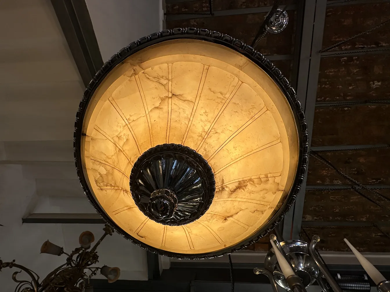 Lampada a sospensione antica con design elegante, luce calda in un ambiente accogliente.