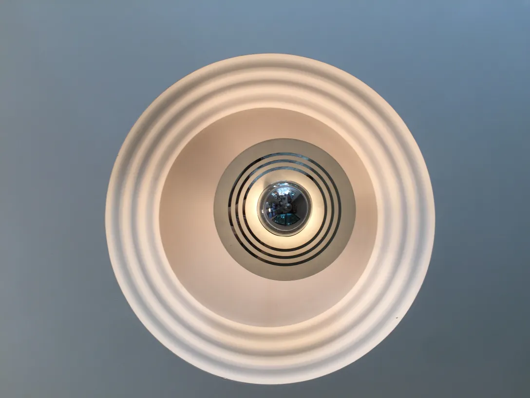 Lámpara de techo antigua con diseño circular y luz suave.