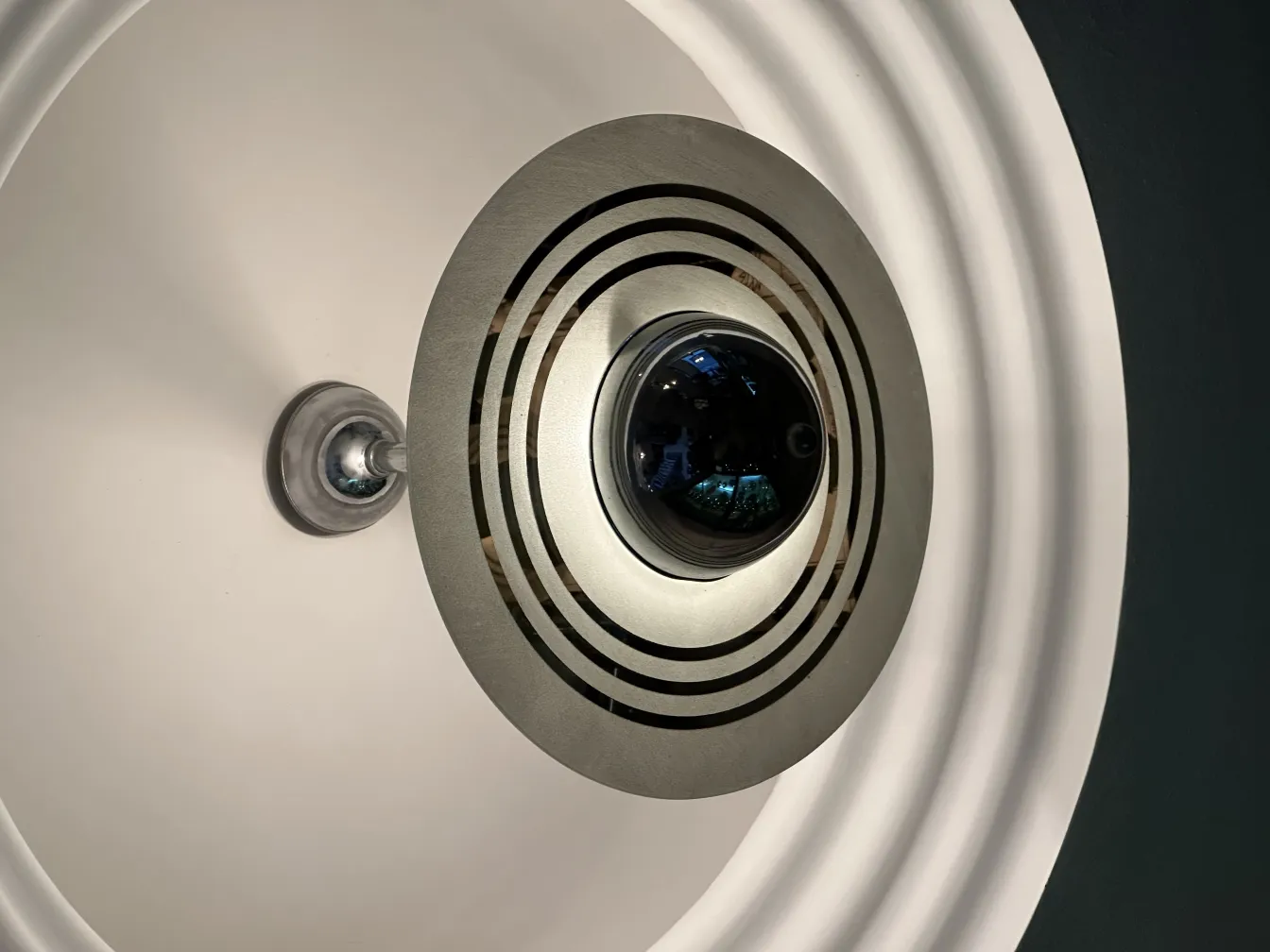 Lampada a sospensione antica con design geometrico al centro.