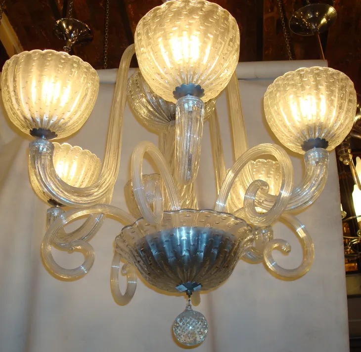 antica lampada a sospensione con braccia curve e luce calda