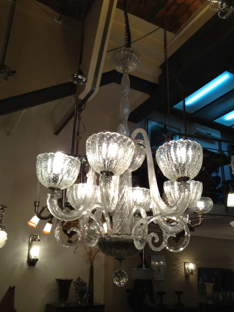 Lámpara de techo antigua con detalles brillantes y curvas elegantes, en un ambiente clásico.