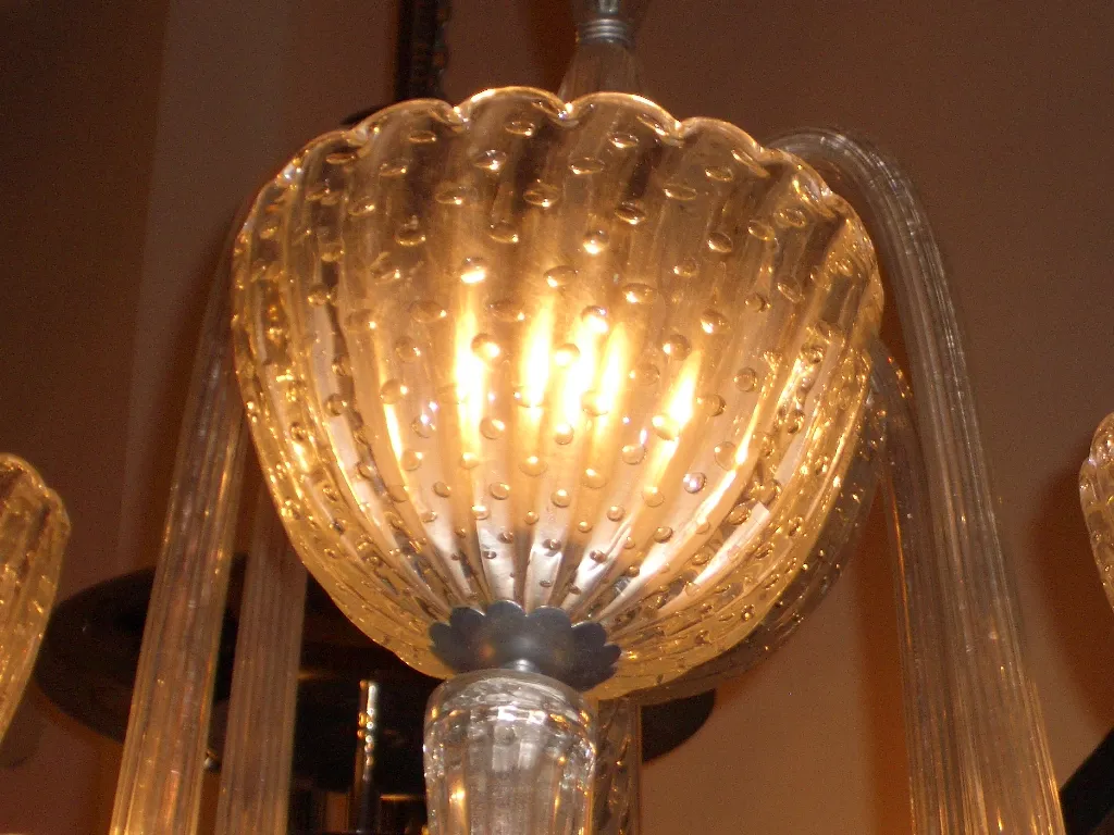 Lampara de techo antigua con detalles decorativos y luz brillante.