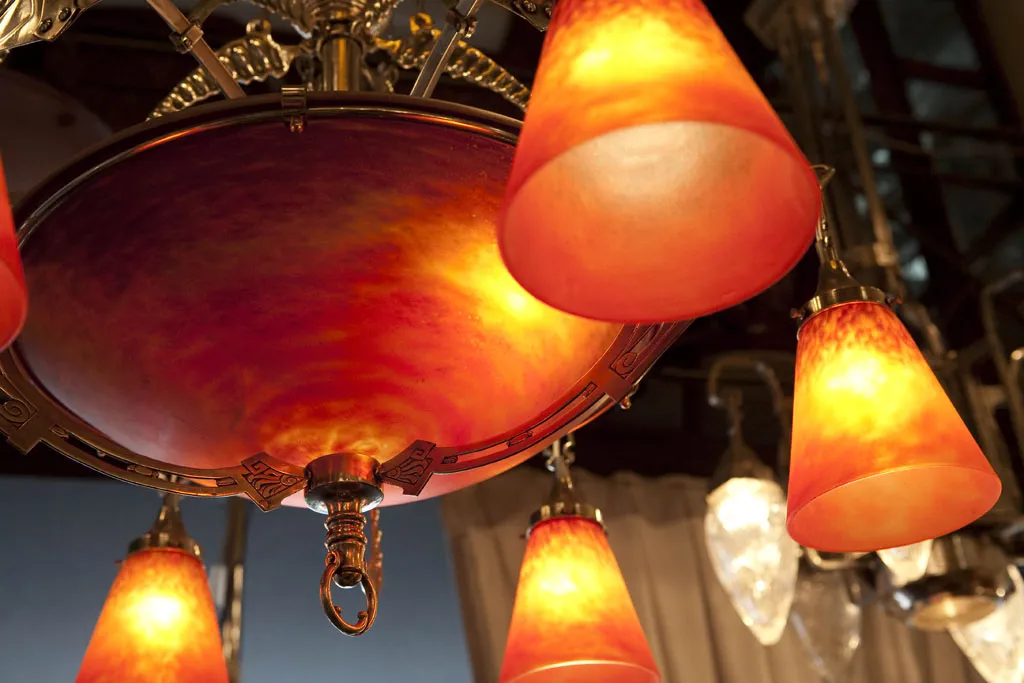 antigua lámpara de techo con luces en tonos cálidos, estilo Charles Schneider