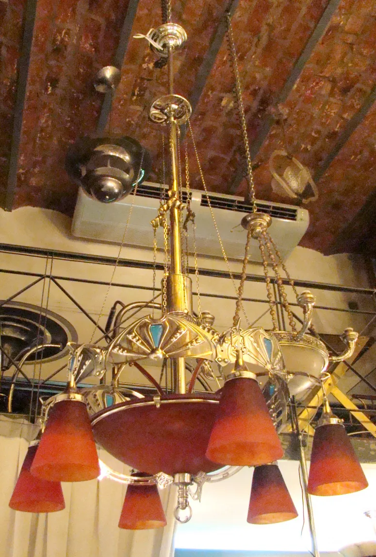 Antique hanging lamp with red bell-shaped shades, Charles Schneider, in a vintage setting.