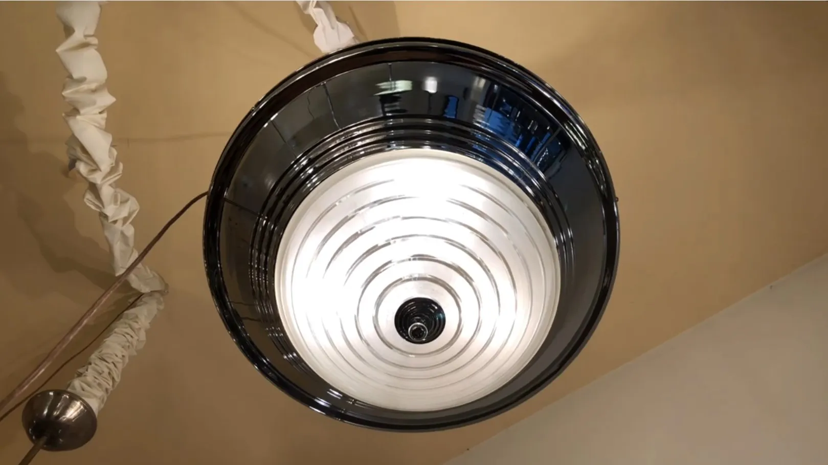 Lámpara de techo antigua con diseño circular, ambiente cálido.