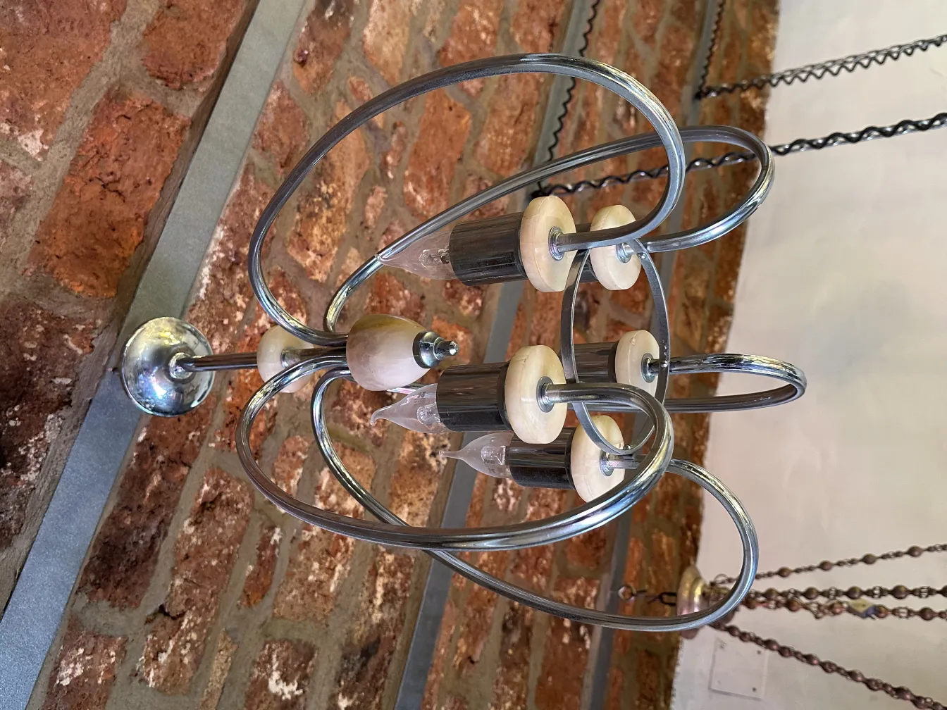 Lámpara de techo antigua con un diseño moderno, situada en una habitación con paredes de ladrillo