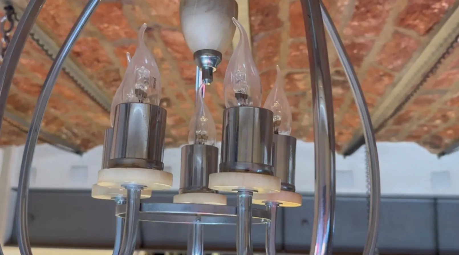 Lámpara de techo antigua con bombillas de diseño elegante en un ambiente acogedor.