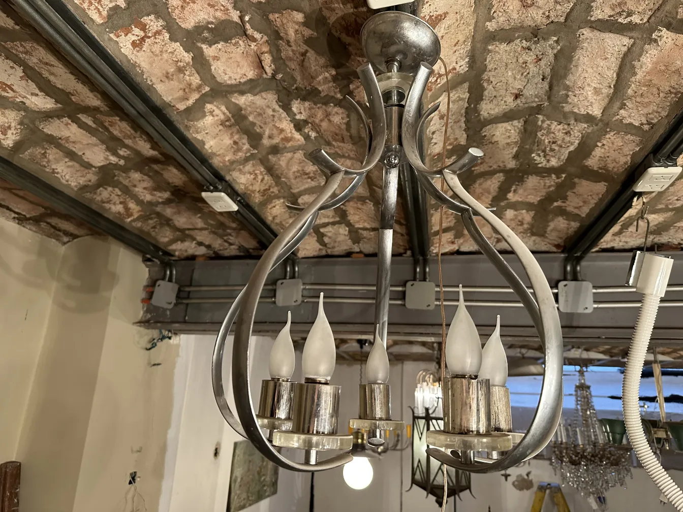 Lâmpada de teto antiga com luzes em forma de vela em um ambiente rústico