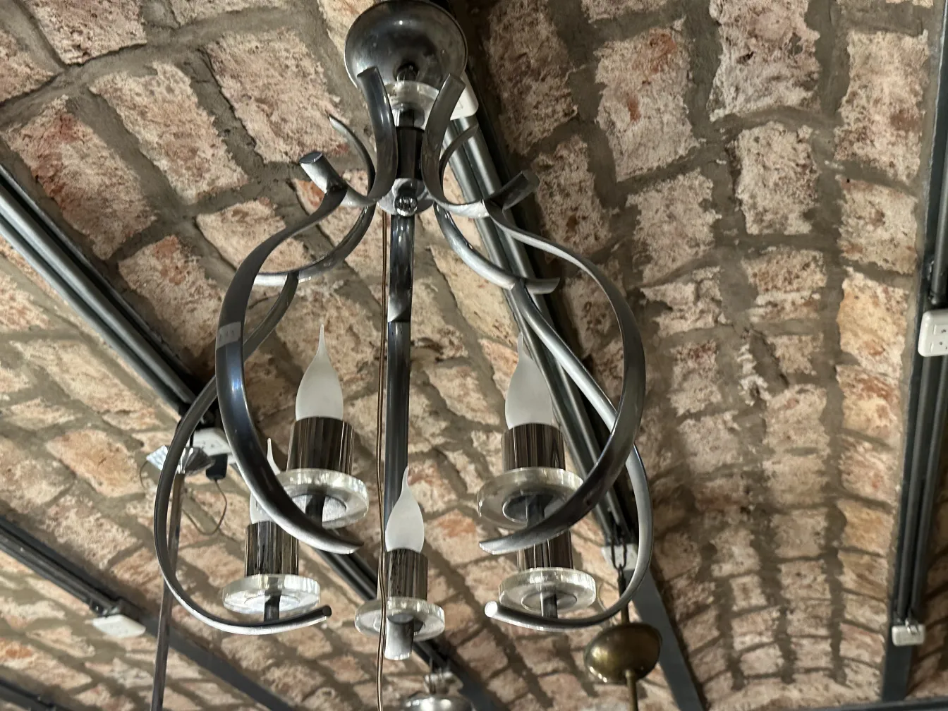 Lustre ancien avec des détails élégants et des lumières brillantes dans un cadre rustique.