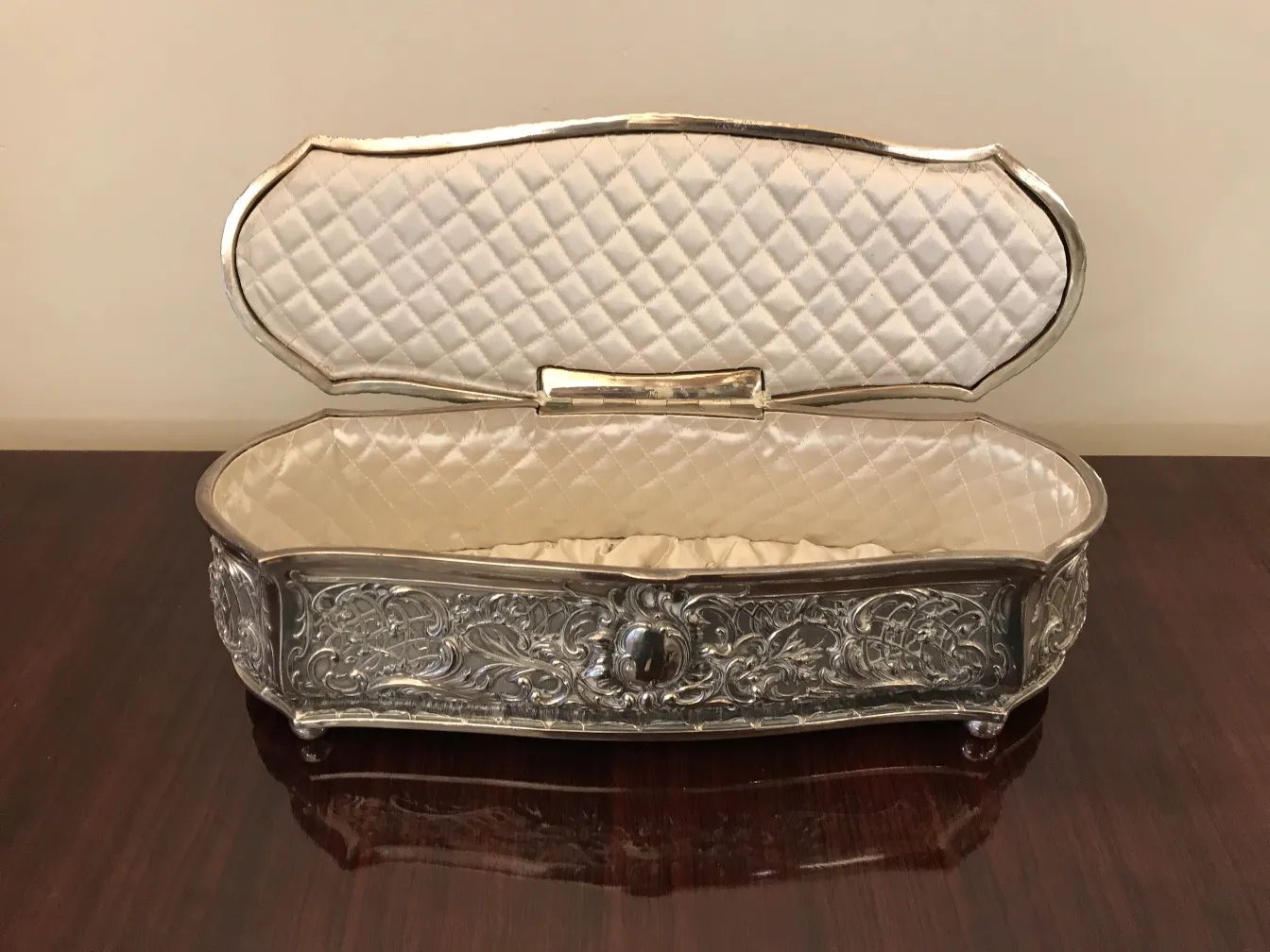 Antique box with decorative design and open lid, light interior