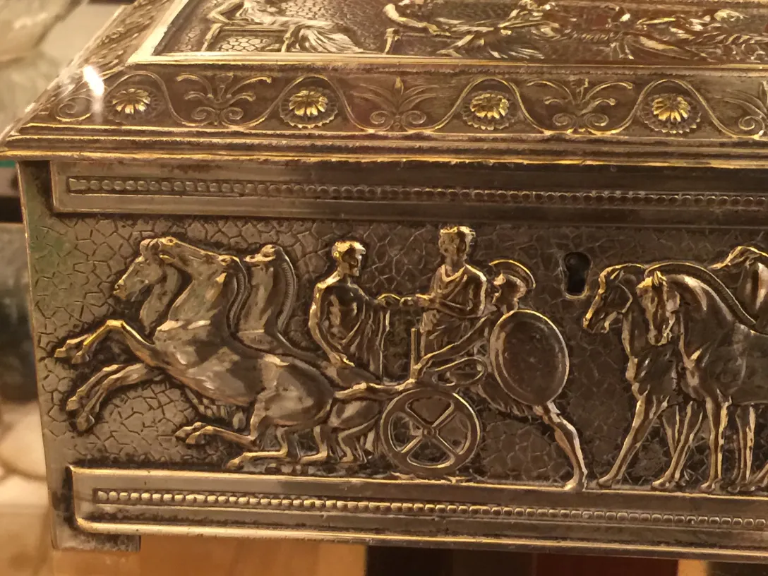 Antike Kiste, verziert mit mythologischen Szenen und Pferden.