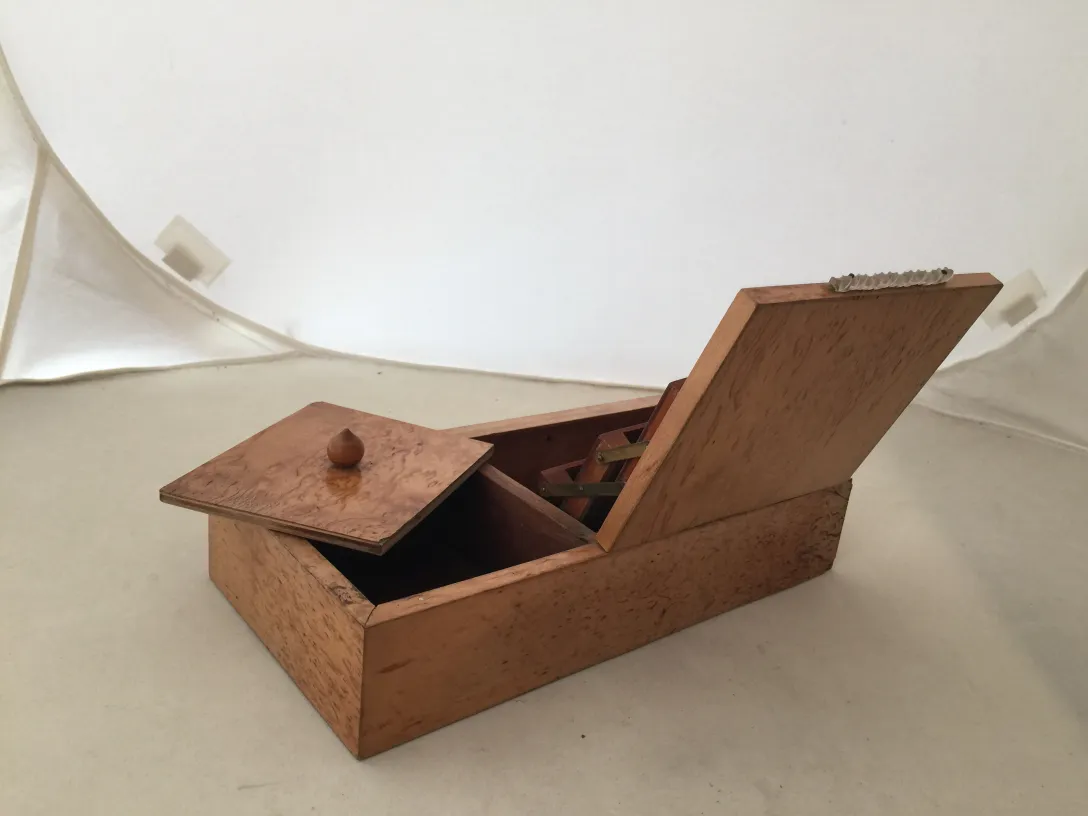 Boîte en bois ancienne avec couvercle, mettant en valeur des détails élégants.