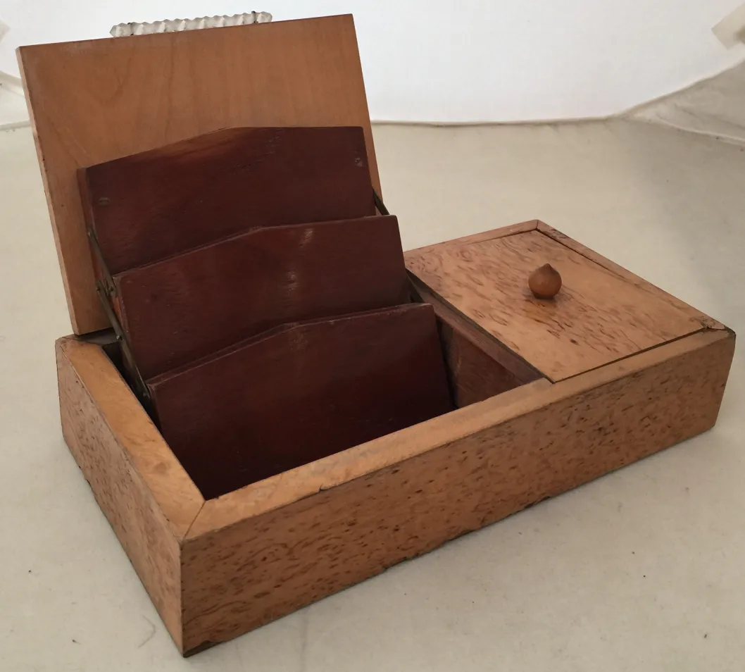 Antique wooden box with internal dividers and a small compartment.