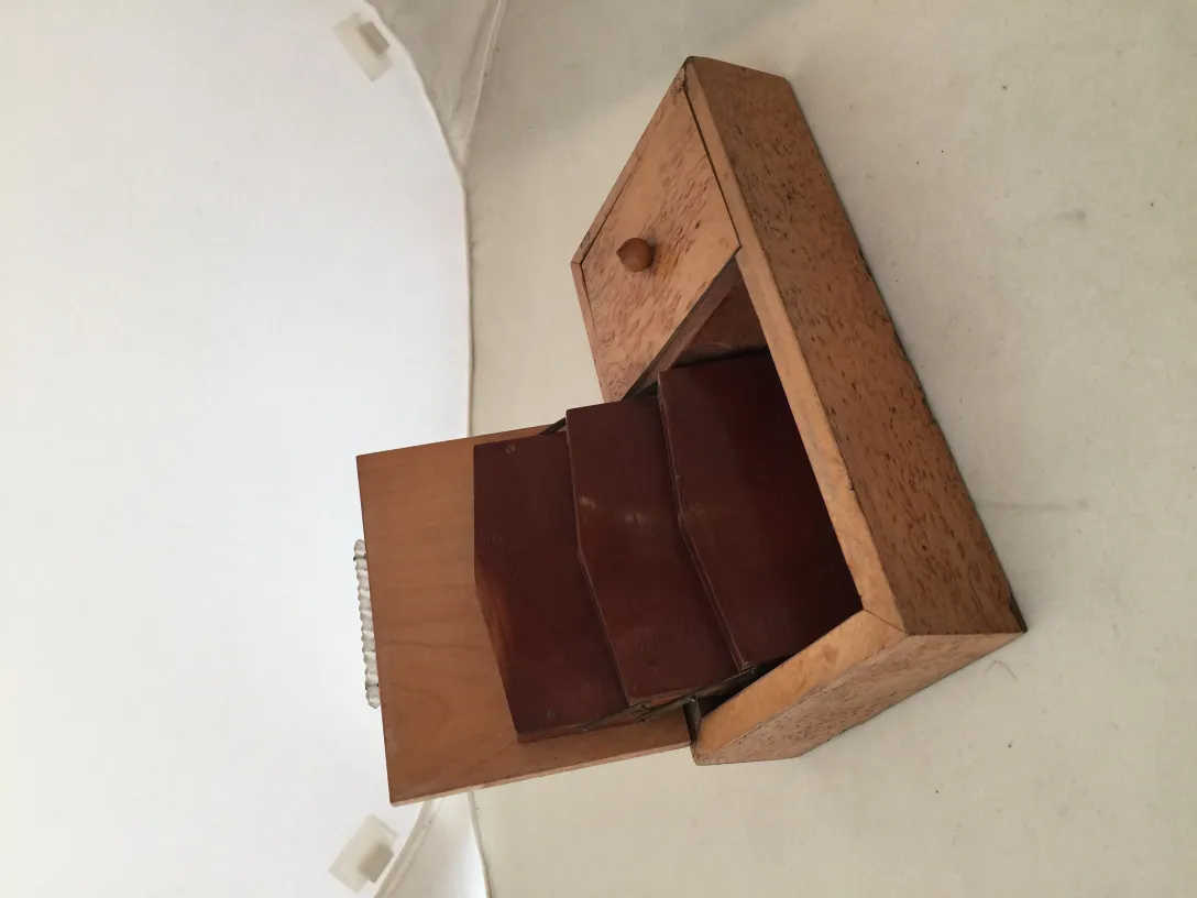Antique wooden box with two compartments and a small drawer against a light background.
