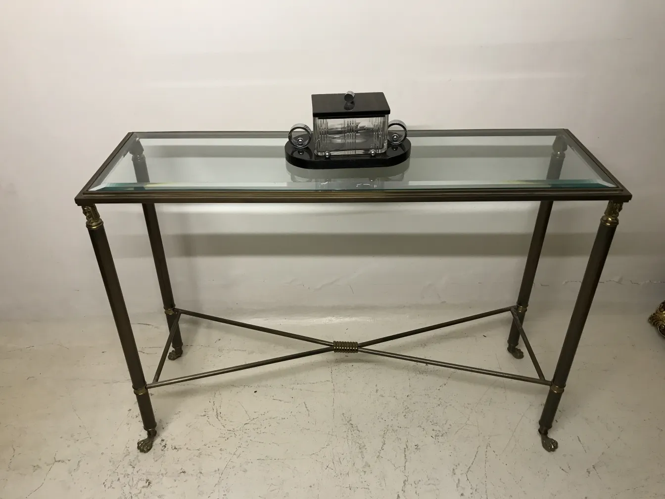 Caja antigua decorativa en una mesa con superficie de vidrio.