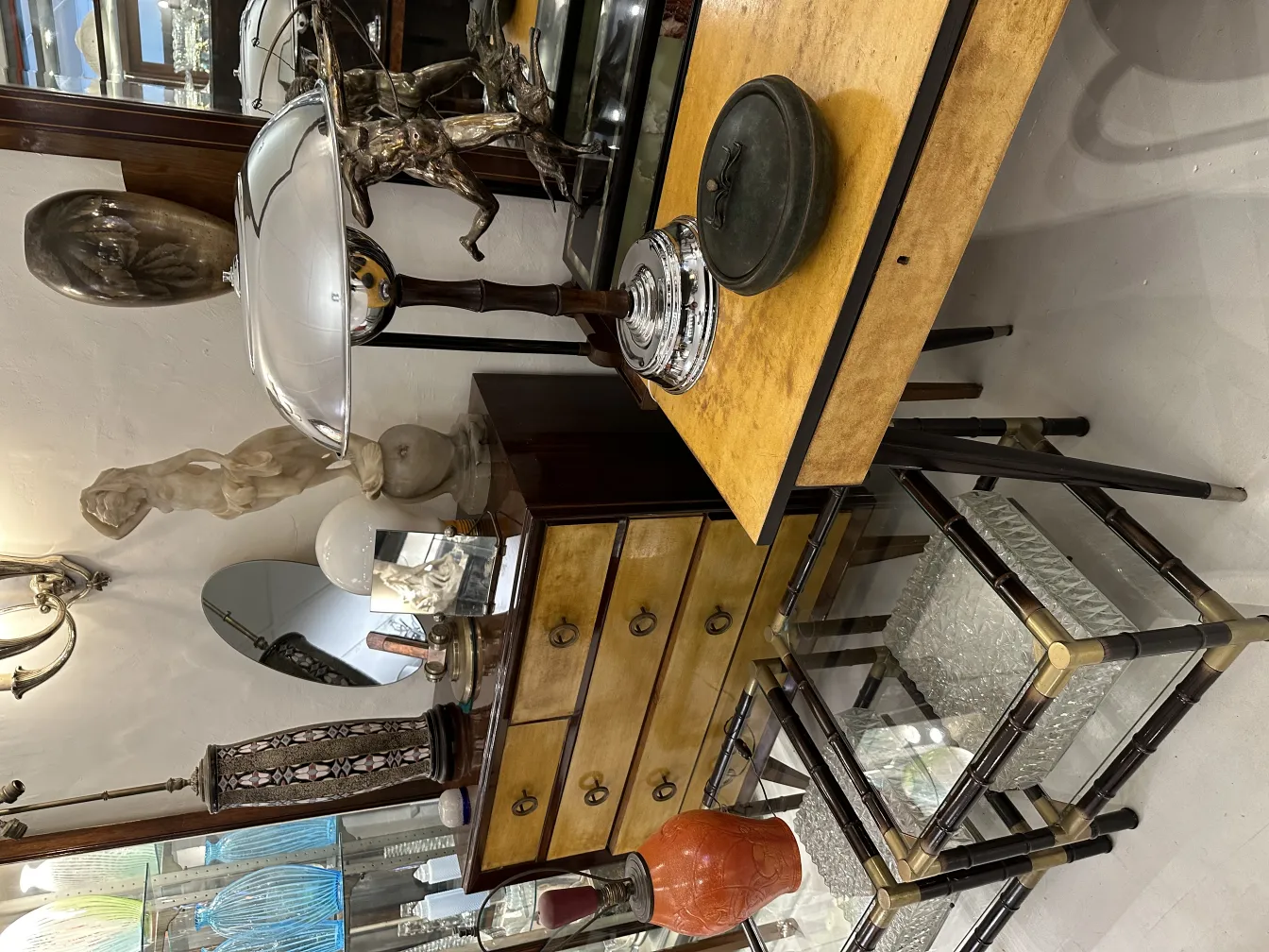 Boîte en bois antique avec détails décoratifs, entourée d'antiquités.