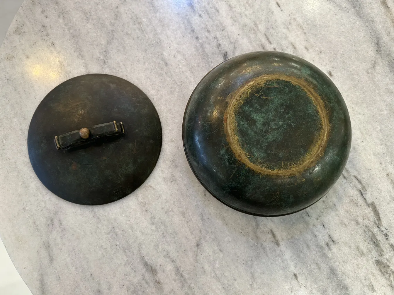 Scatola antica con coperchio rotondo e design unico.