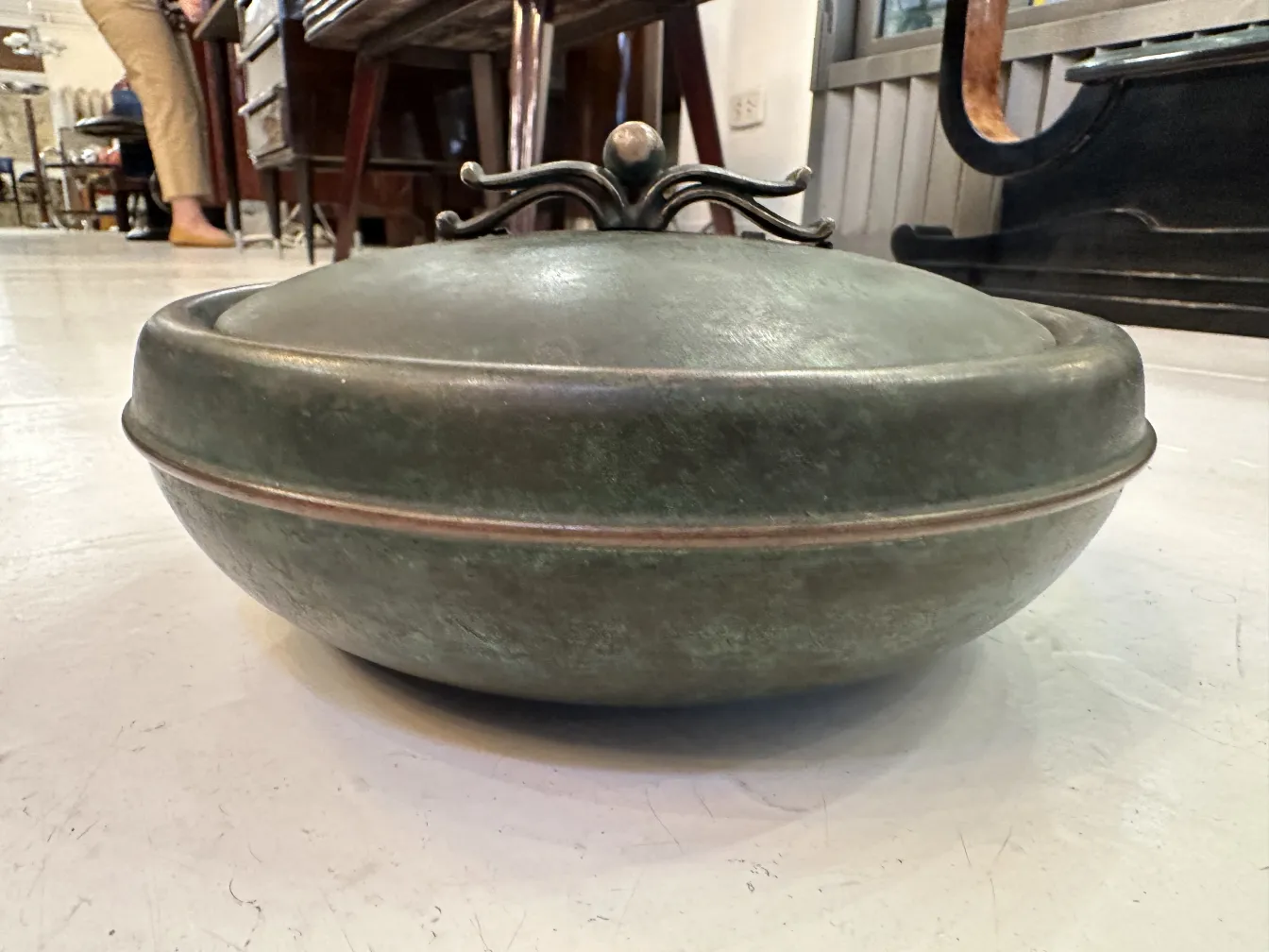Antique round box with decorative lid in an antique setting.