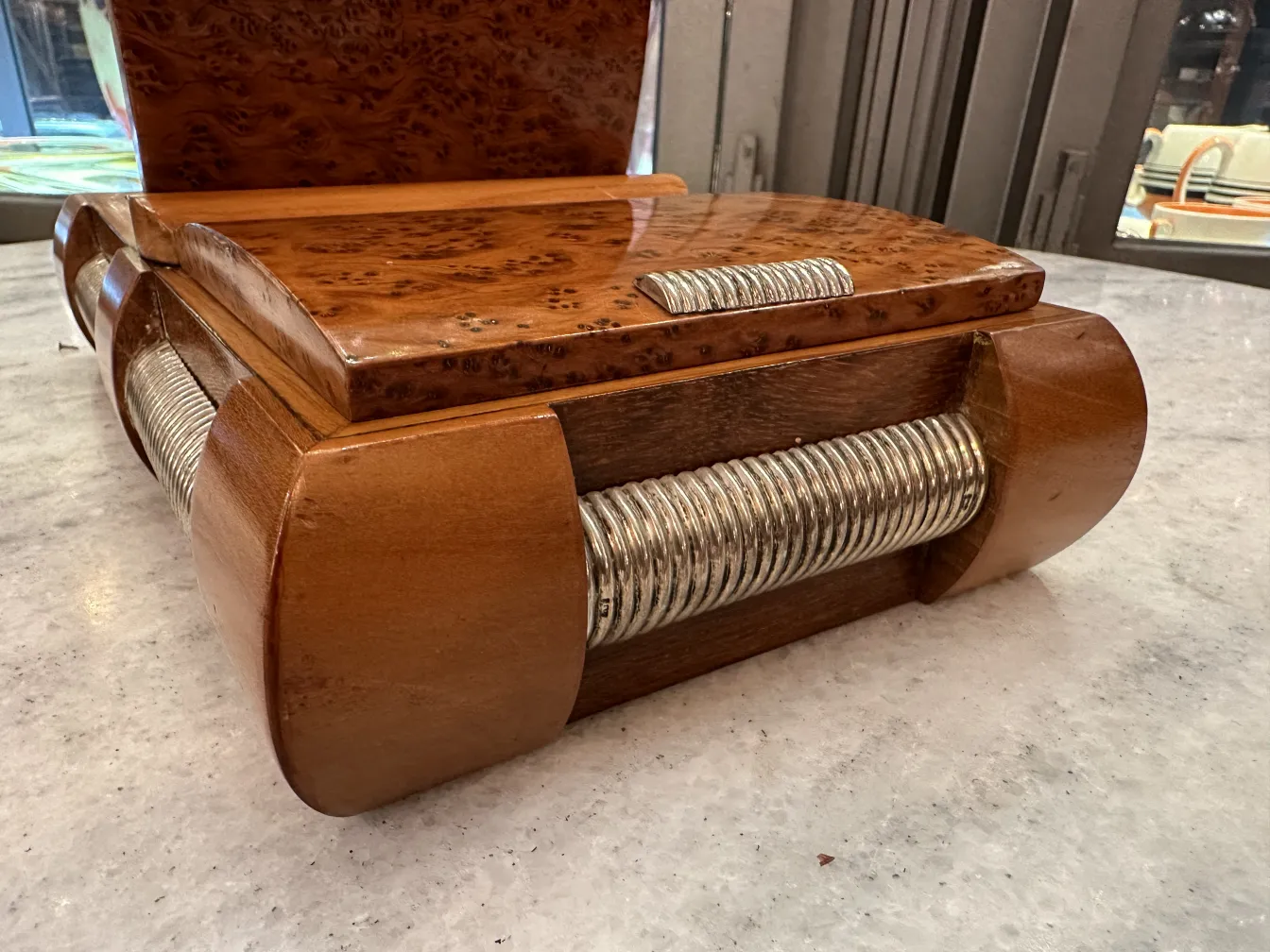 Antike Kiste mit glänzender Oberfläche und elegantem Design in gemütlicher Umgebung.