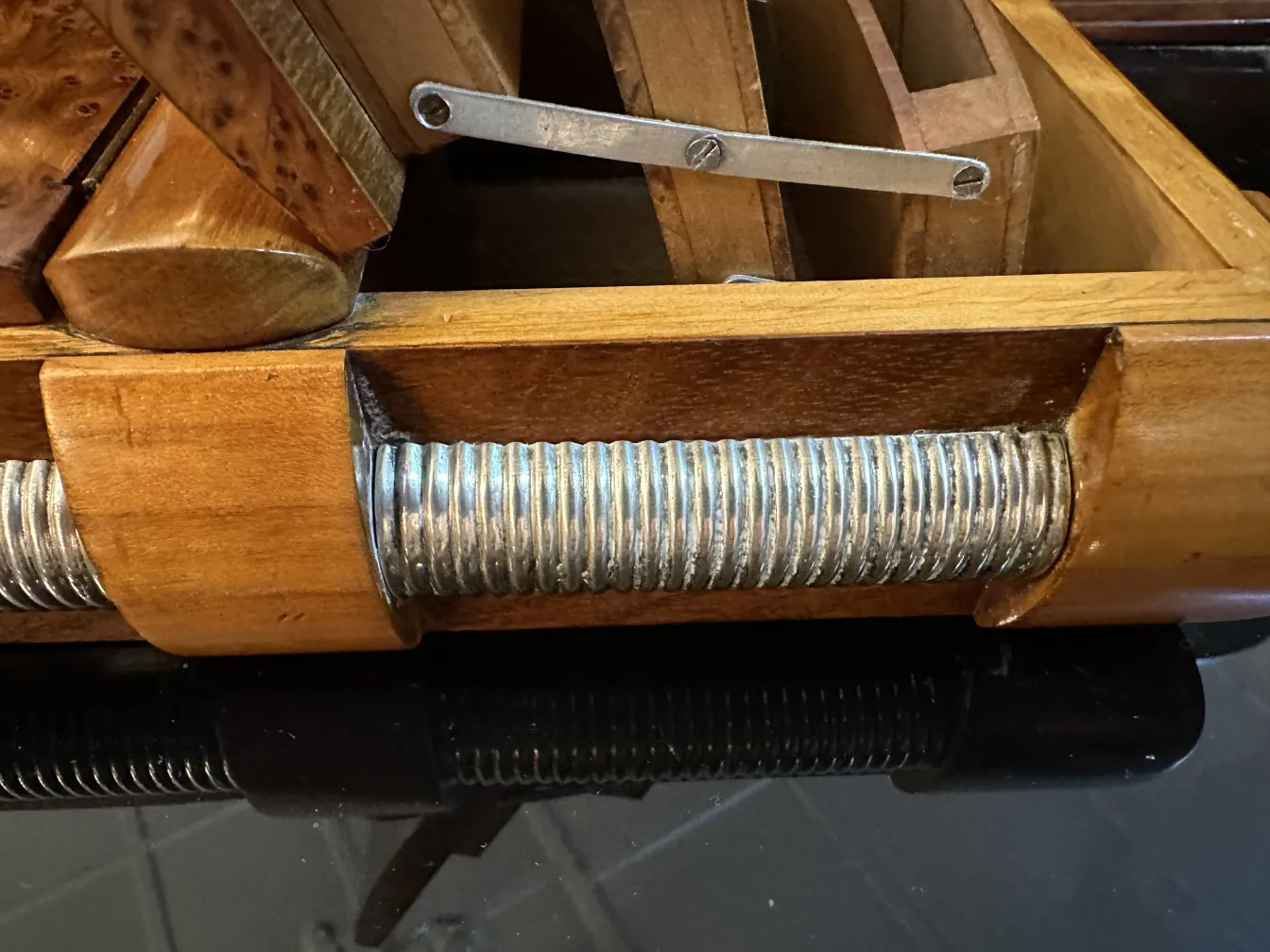 Caja antigua de madera con detalles de metal y divisores.