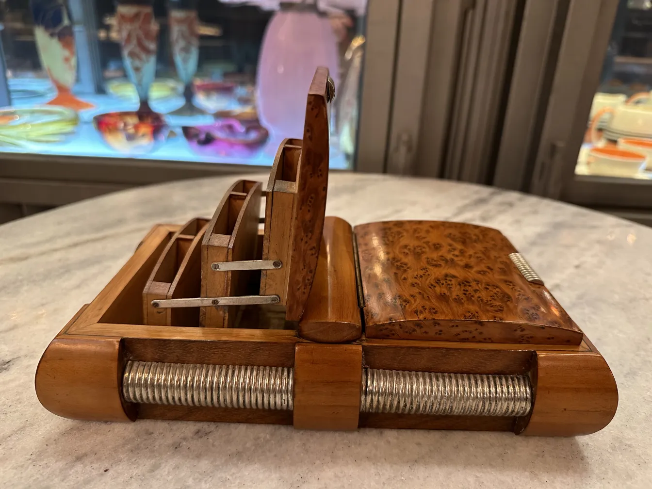 Scatola antica in legno con scomparti e dettagli decorativi.