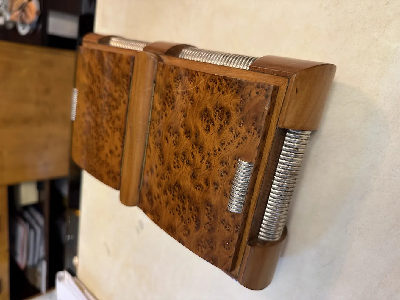 Scatola antica in legno con dettagli decorativi e trama.