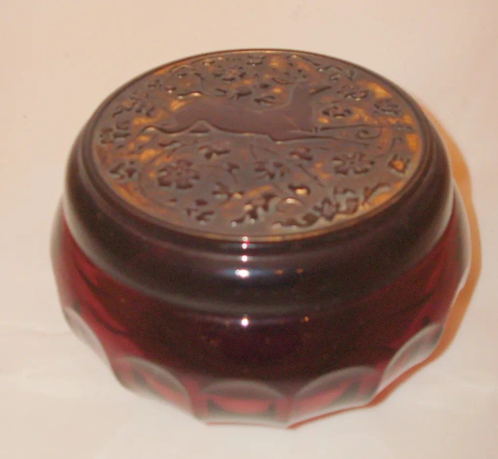 Caja antigua de cristal con tapa decorativa en forma de relieve.