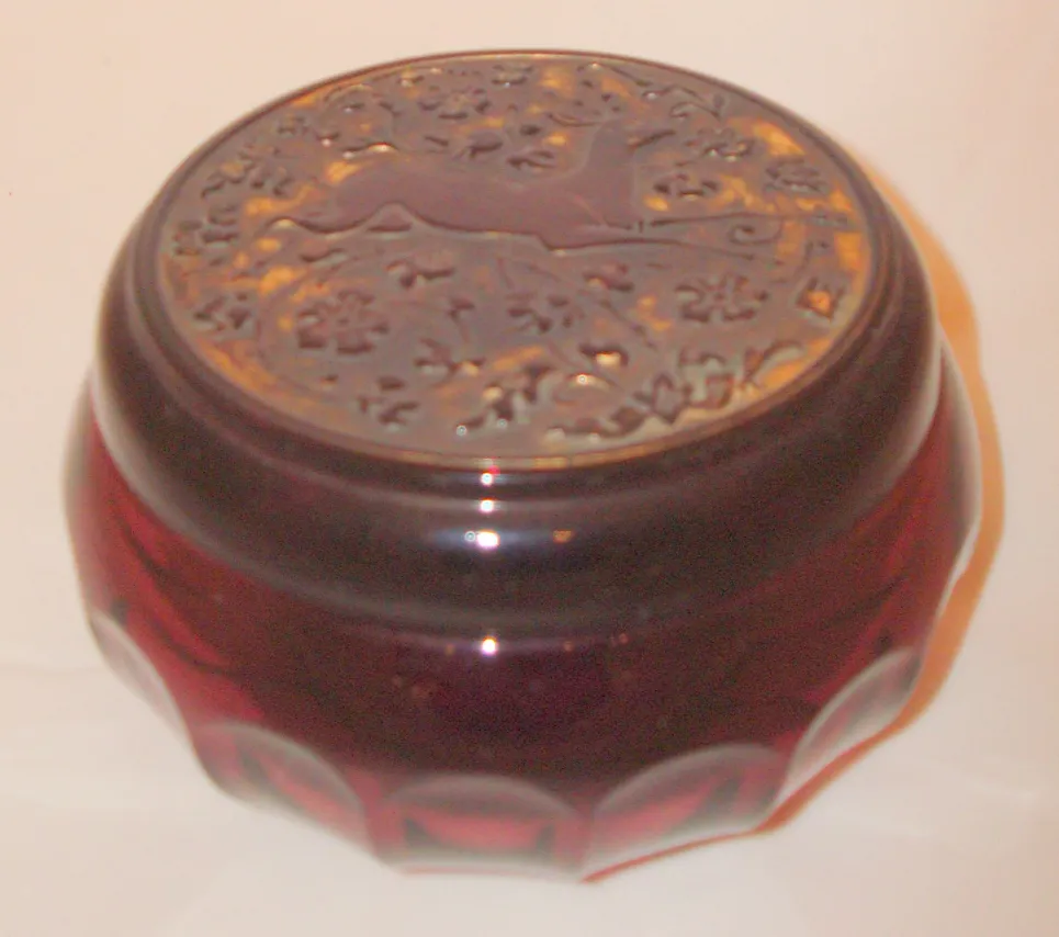 Caixa antiga com tampa decorativa em vermelho escuro, detalhes intrincados.