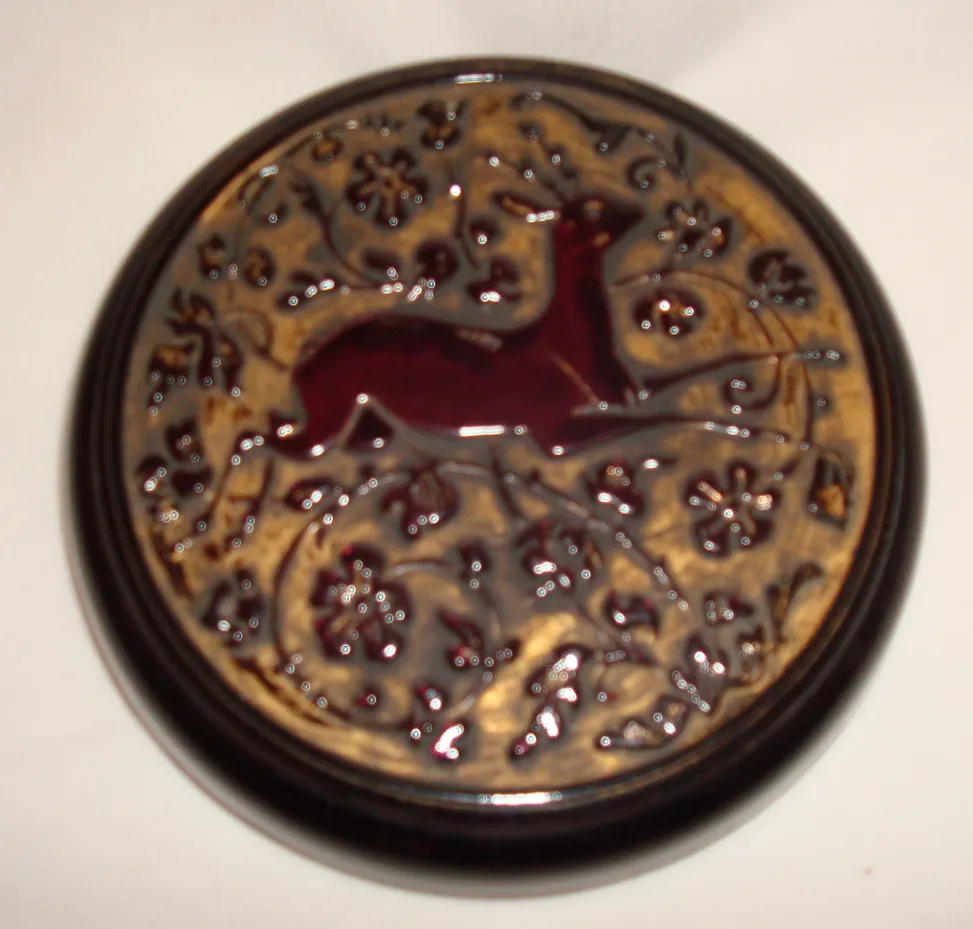 Boîte ancienne avec des détails en relief d'un cerf entouré de fleurs.