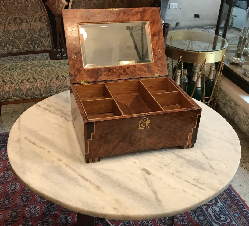 Boîte ancienne avec compartiments et reflet sur le couvercle.