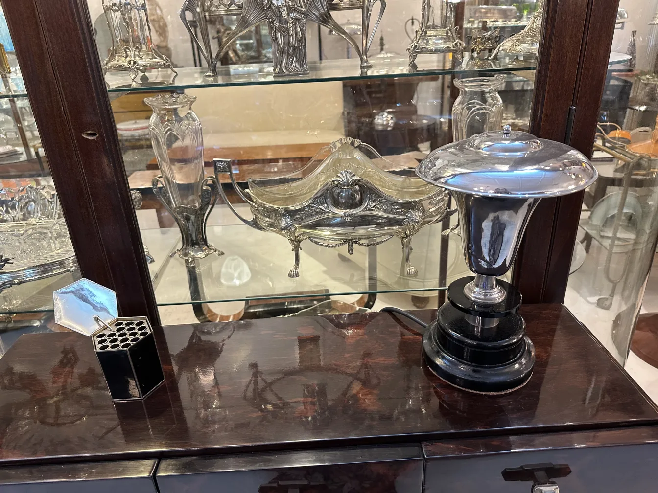 Decorative antique box on a shelf full of antiques.