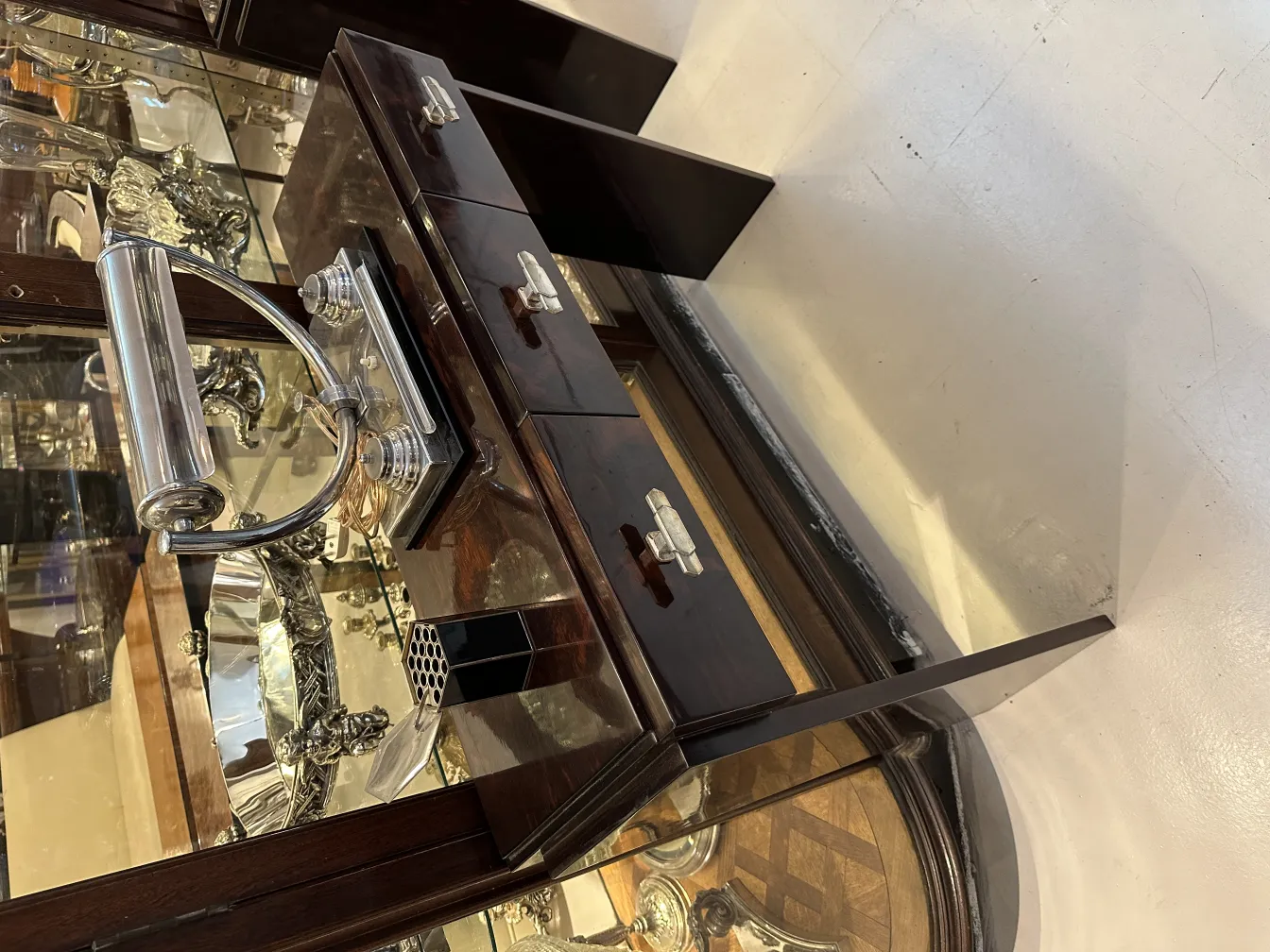 caja antigua con detalles y compartimentos visibles, rodeada de antigüedades