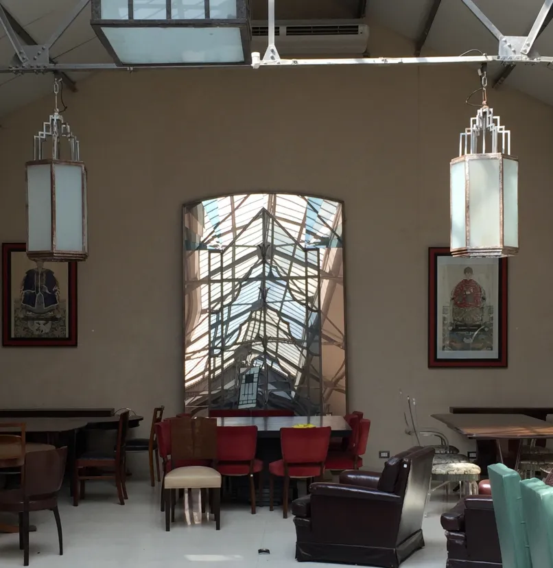 Dos faroles antiguos colgando en un ambiente elegante con muebles variados.