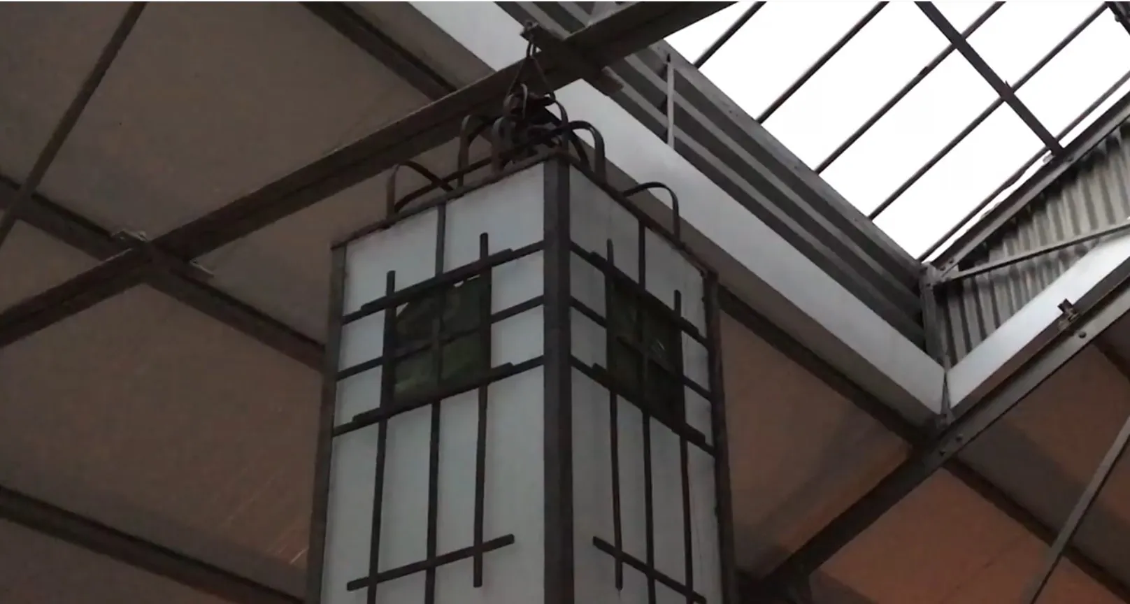 Due lanterne appese antiche con dettagli decorativi in un ambiente moderno.