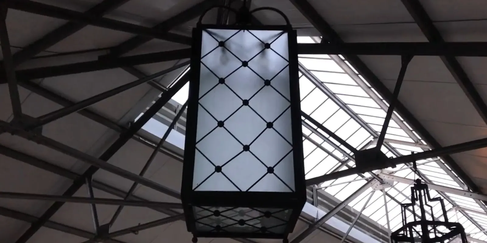 duas lanternas antigas penduradas em um ambiente iluminado