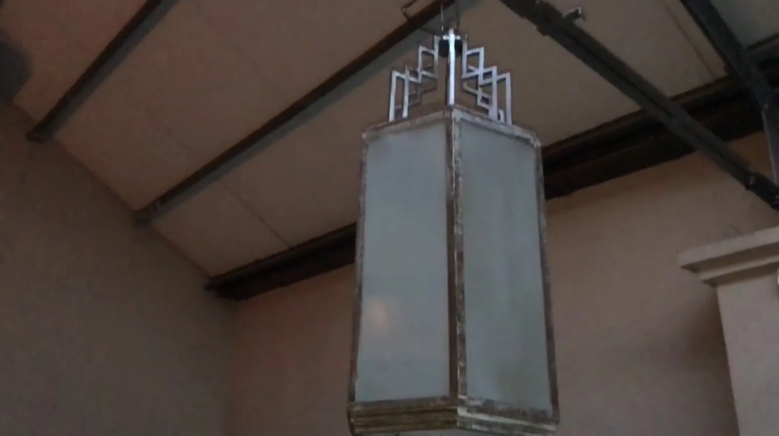 Duas lanternas antigas penduradas com design único em um ambiente acolhedor.