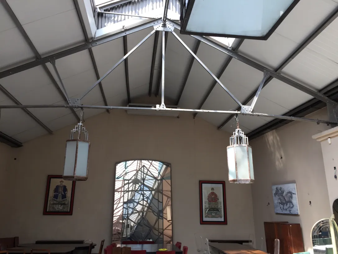 Two antique lanterns hanging in a warm indoor setting.