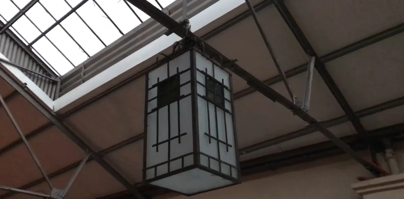 Due lanterne decorative antiche sospese su uno sfondo architettonico