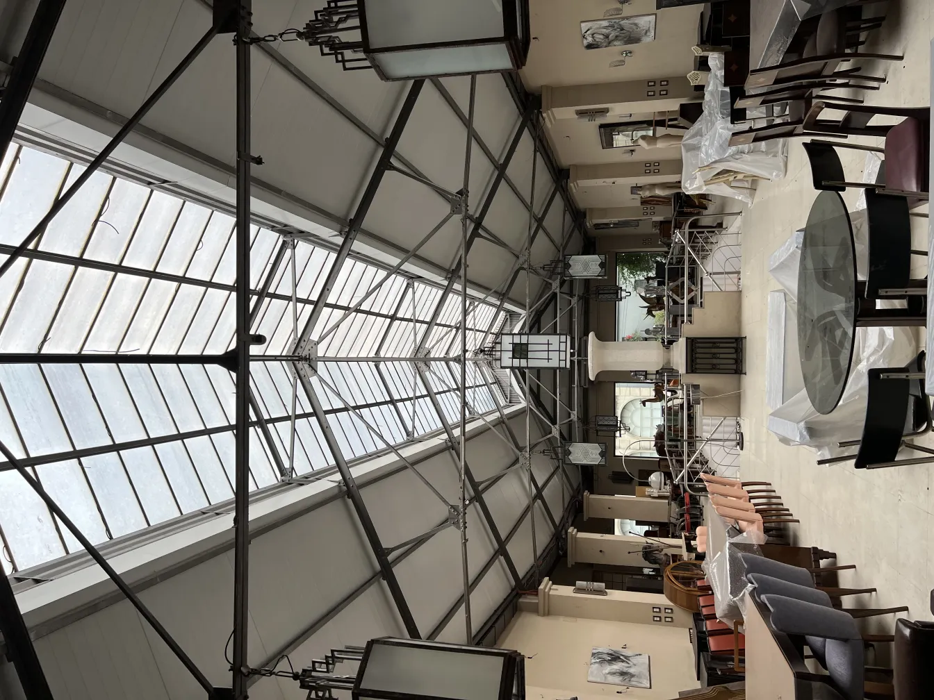 넓은 실내 공간에 테이블과 의자와 함께 걸려 있는 두 개의 고전 랜턴