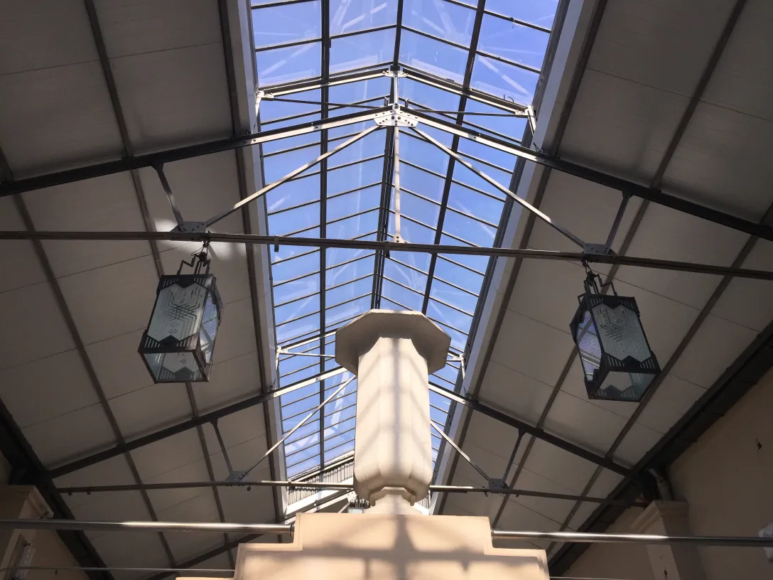 Deux lanternes anciennes suspendues dans un plafond lumineux.