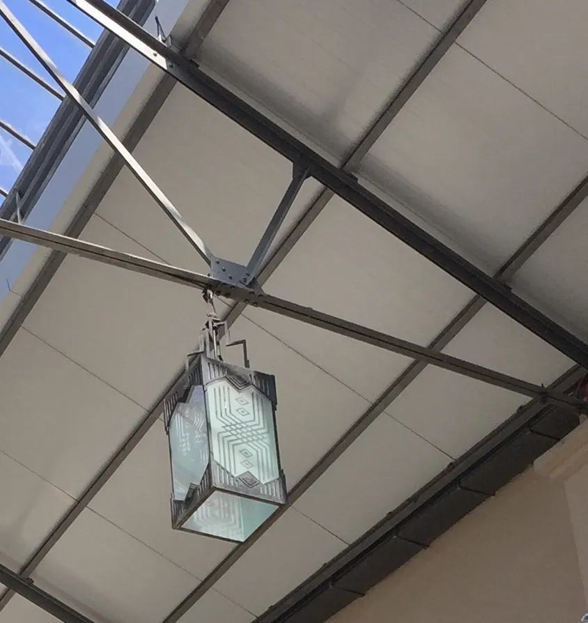 Dos faroles antiguos colgantes con diseño elegante y detalles artísticos, en un ambiente moderno.