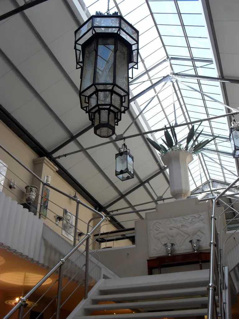 2 antike Lampen, die von der Decke in einer stilvollen Umgebung hängen.