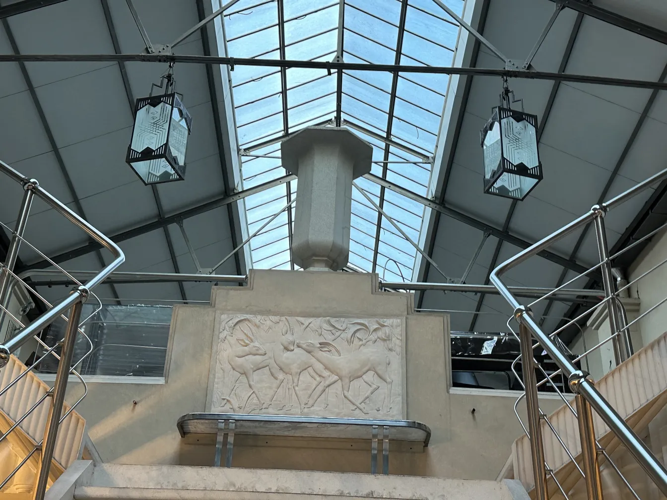 Dois faróis antigos pendurados, com detalhes decorativos, iluminação ambiente.